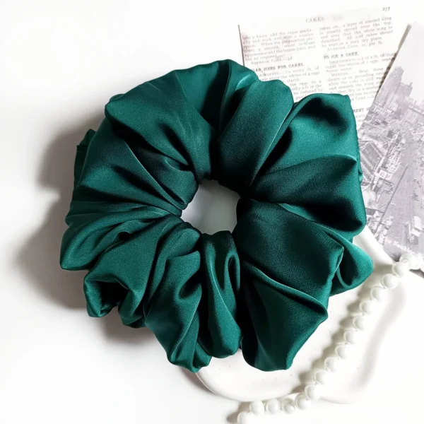 Scrunchie XL z satyny jedwabnej w kolorze butelkowej zieleni.