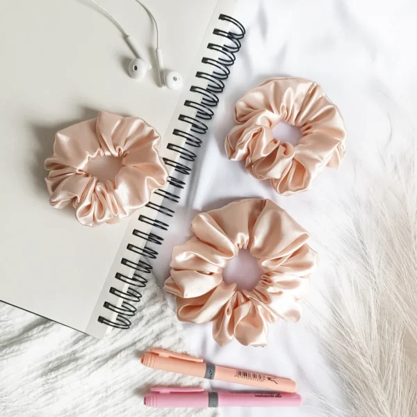 Scrunchie z satyny w kolorze brzoskwiniowym.