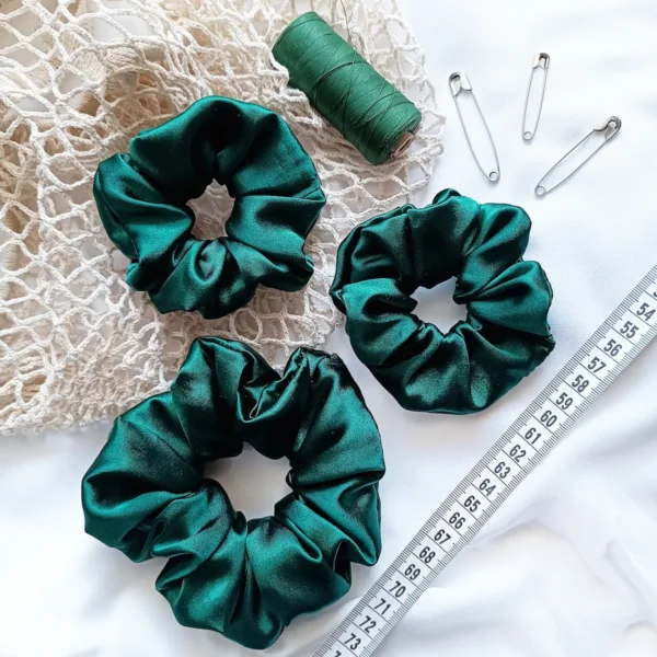 Scrunchie z satyny w kolorze butelkowej zieleni.