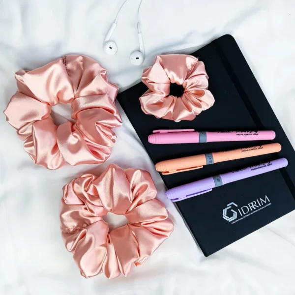 Scrunchie z satyny w kolorze łososiowym.