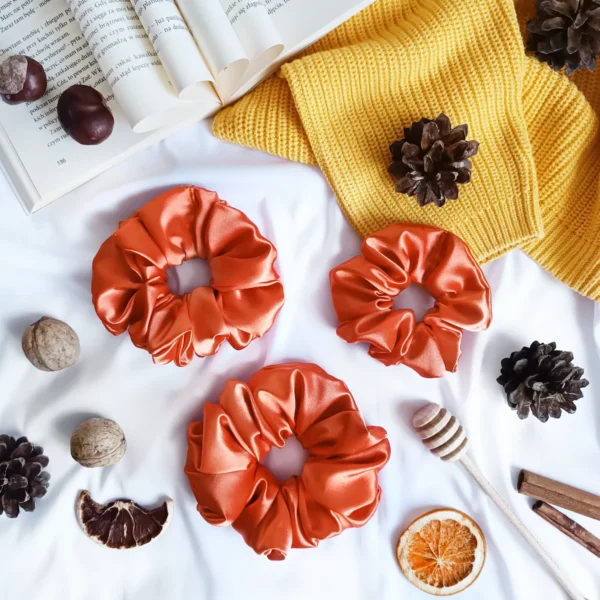 Scrunchie z satyny w kolorze pomarańczowym.