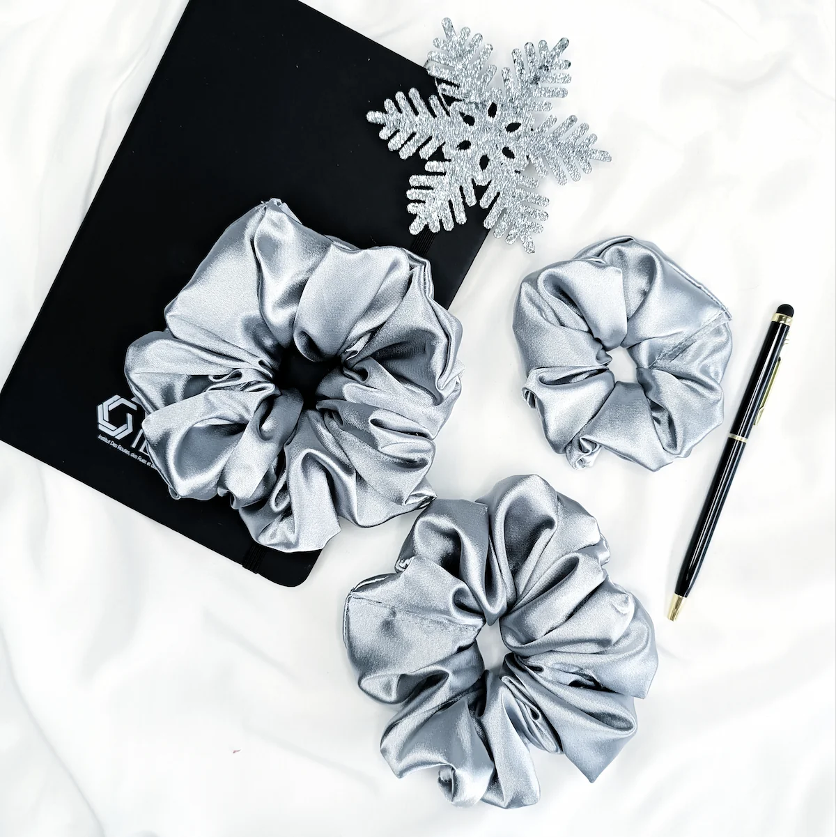 Scrunchie z satyny w kolorze srebrnym.