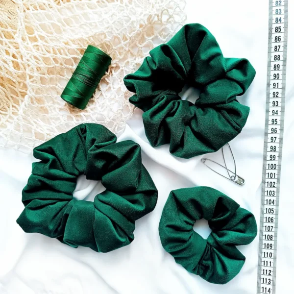 Scrunchie z weluru w kolorze butelkowej zieleni.