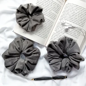 Scrunchie z weluru w kolorze ciemnoszarym.