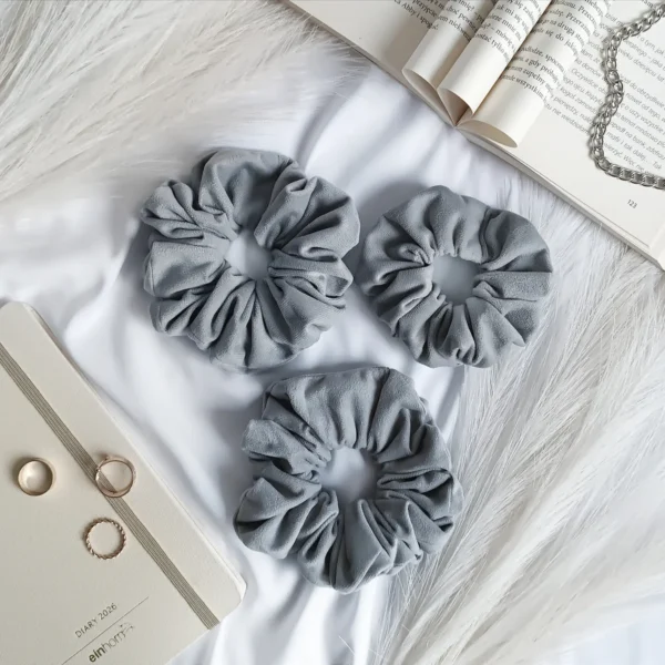Scrunchie z weluru w kolorze jasnoszarym.