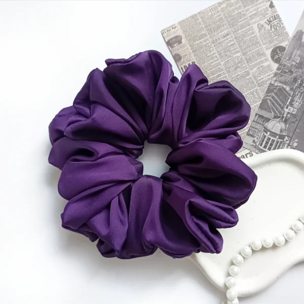 Scrunchie XL z satyny jedwabnej w kolorze fioletowym.