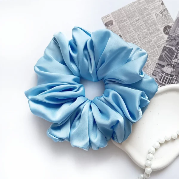 Scrunchie XL z satyny jedwabnej w kolorze jasnoniebieskim.