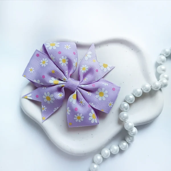 Kokarda dla dzieci ze wstążki rypsowej jasnofioletowa w kwiaty.