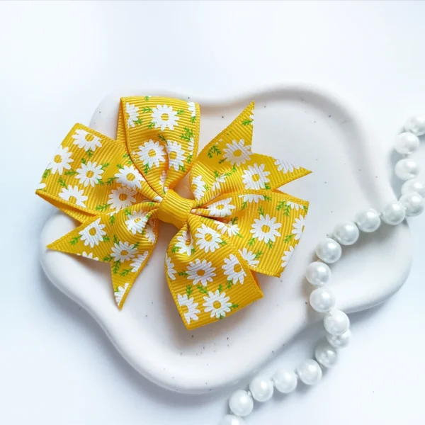 Kokarda dla dzieci ze wstążki rypsowej żółta w kwiaty.