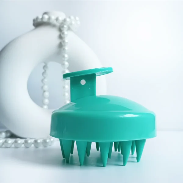 Masażer do skóry głowy w kolorze turkusowym.