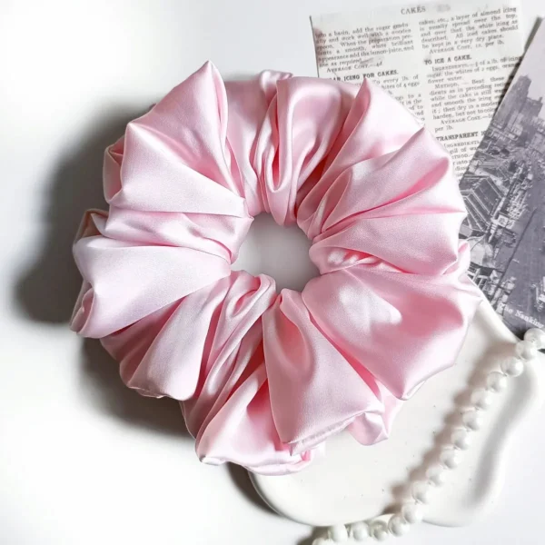Scrunchie XL z satyny jedwabnej w kolorze jasnoróżowym.